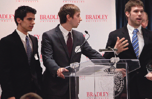 3 business men presenting at a conference